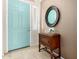 Welcoming foyer with a stylish teal-colored front door, a decorative table, and a round mirror creating a bright entrance at 22232 N 48Th St, Phoenix, AZ 85054