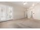 Spacious living room featuring plush carpeting and access to outdoor patio through double doors at 22232 N 48Th St, Phoenix, AZ 85054