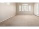 Bright living room with neutral carpeting, and shuttered windows for plenty of natural light at 22232 N 48Th St, Phoenix, AZ 85054