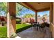 Cozy covered patio with outdoor dining set, perfect for enjoying the landscaped backyard at 22232 N 48Th St, Phoenix, AZ 85054