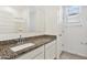 Bathroom with granite countertop vanity, white cabinets, and large mirror at 22540 N Lynn St, Maricopa, AZ 85138