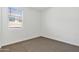 Neutral bedroom featuring fresh white walls, tan carpet, and bright window at 22540 N Lynn St, Maricopa, AZ 85138