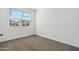 Neutral bedroom featuring fresh white walls, tan carpet, and bright window at 22540 N Lynn St, Maricopa, AZ 85138