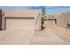 Beige home featuring a private garage and neutral-toned desert landscape with a paved driveway at 2320 S Forest Ave, Tempe, AZ 85282