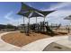 Community playground featuring modern equipment, a shaded canopy, and soft ground covering at 24113 W Bowker St, Buckeye, AZ 85326