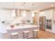 Modern kitchen with white cabinetry, stainless steel appliances, large island with counter seating, and stylish lighting at 2480 W Rowel Rd, Phoenix, AZ 85085