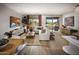 Bright living room with white sofa, stylish decor, and sliding glass doors to outdoor patio with grill at 2480 W Rowel Rd, Phoenix, AZ 85085