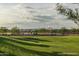 Scenic basketball court with hoops, shaded seating, and lush green surroundings under a partly cloudy sky at 2486 W Rowel Rd, Phoenix, AZ 85085