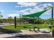 Inviting picnic area with tables, chairs, and sunshades amid landscaped greenery and a bright blue sky at 2486 W Rowel Rd, Phoenix, AZ 85085