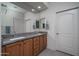 Bathroom featuring double sinks with granite countertops and modern fixtures and white doors at 26017 W Maple Dr, Buckeye, AZ 85396