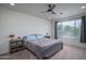 Cozy bedroom featuring a ceiling fan, large window, and stylish furnishings at 26017 W Maple Dr, Buckeye, AZ 85396