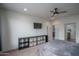 Bedroom with ceiling fan, shelving storage, and convenient access to bathroom and hallway at 26017 W Maple Dr, Buckeye, AZ 85396