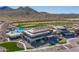 Aerial view of clubhouse featuring a pool, golf course, and desert landscape for premier leisure and recreation at 26017 W Maple Dr, Buckeye, AZ 85396