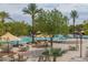 Resort-style community pool featuring palm trees, shaded seating areas, a waterfall, and ample space for recreation at 26017 W Maple Dr, Buckeye, AZ 85396
