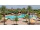 Expansive community pool area with palm trees, multiple pools, lounge areas, and shaded seating for residents at 26017 W Maple Dr, Buckeye, AZ 85396