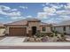Charming single-story home with well-maintained desert landscaping and a two-car garage under a sunny sky at 26017 W Maple Dr, Buckeye, AZ 85396