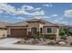 Charming single-story home featuring a tiled roof, well-manicured landscaping, and an attached two-car garage at 26017 W Maple Dr, Buckeye, AZ 85396