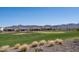 Back view of lovely community homes overlooking the meticulously kept golf course and desert mountain backdrop at 26017 W Maple Dr, Buckeye, AZ 85396