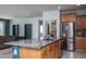 Open kitchen with stainless steel appliances, granite countertops, island sink, and a walk-in pantry at 26017 W Maple Dr, Buckeye, AZ 85396