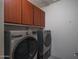 Convenient laundry room with modern washer and dryer, complemented by upper cabinets for organized storage at 26017 W Maple Dr, Buckeye, AZ 85396