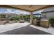 Covered patio with built in grill and outdoor seating overlooking the desert landscape at 26017 W Maple Dr, Buckeye, AZ 85396