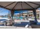 Relaxing lounge area under a shaded canopy, offering a view of the pool and beautiful community buildings at 26017 W Maple Dr, Buckeye, AZ 85396