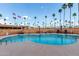 Inviting community pool surrounded by brick fencing, patio furniture, and palm trees at 2700 E Allred Ave # R87, Mesa, AZ 85204