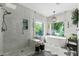 Bathroom featuring standalone tub and shower with bench seating in bright natural light at 3209 E Fox St, Mesa, AZ 85213
