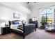 A comfortably styled bedroom showcases a large window, carpeted floors, and a dark-wood bedroom set at 3209 E Fox St, Mesa, AZ 85213