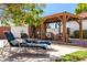 Outdoor seating area boasts a wooden pergola, cushioned seating, and shaded lounge chairs at 3209 E Fox St, Mesa, AZ 85213