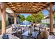 Comfortable outdoor seating is provided by neutral couches and rocking chairs inside the wooden pergola at 3209 E Fox St, Mesa, AZ 85213