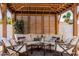 A wood pergola features comfortable seating with neutral cushions and sun-shielding privacy slats at 3209 E Fox St, Mesa, AZ 85213