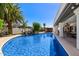 A stunning pool area is showcased with palm trees and a rock waterfall feature in the backyard at 3209 E Fox St, Mesa, AZ 85213