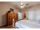 This bedroom features a wooden bedframe, dresser, ceiling fan and bathroom access at 37809 N 9Th Pl, Phoenix, AZ 85086