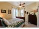 Cozy bedroom with a wood frame bed, ceiling fan, and decorative dresser at 37809 N 9Th Pl, Phoenix, AZ 85086