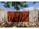 Rustic metal gate surrounded by block wall with lush foliage at 37809 N 9Th Pl, Phoenix, AZ 85086