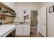 Bright laundry room with cabinets, shelving, sink, and modern appliances at 37809 N 9Th Pl, Phoenix, AZ 85086