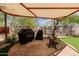 Covered outdoor grilling area featuring a bench and lush landscaping at 37809 N 9Th Pl, Phoenix, AZ 85086