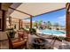 Covered outdoor patio with a firepit and furniture, overlooking the swimming pool and lush landscaping at 37809 N 9Th Pl, Phoenix, AZ 85086