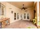 Cozy covered patio with French doors, a ceiling fan, a buffet, and patterned tile flooring at 37809 N 9Th Pl, Phoenix, AZ 85086
