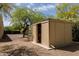 Storage shed with open door, surrounded by gravel landscaping and mature trees at 37809 N 9Th Pl, Phoenix, AZ 85086