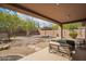 Relaxing backyard with covered patio, desert landscaping, and lounge seating at 41202 N Rolling Green Way, Anthem, AZ 85086