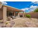 Well-maintained backyard featuring desert landscaping, covered patio, and outdoor seating area at 41202 N Rolling Green Way, Anthem, AZ 85086
