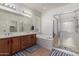 Bathroom with double vanity, soaking tub, glass enclosed shower, and tiled floors at 41202 N Rolling Green Way, Anthem, AZ 85086