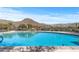 Community pool with mountain views and lounge chairs, offering a relaxing outdoor space for residents at 41202 N Rolling Green Way, Anthem, AZ 85086