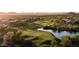 Scenic aerial view of a well-manicured golf course with a water hazard and lush greenery in a vibrant community at 41202 N Rolling Green Way, Anthem, AZ 85086