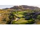 Manicured golf course winds through a desert landscape with homes nestled among lush greenery, offering a scenic residential setting at 41202 N Rolling Green Way, Anthem, AZ 85086