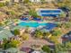 Aerial view of community pool area featuring lounge chairs, shade structures, and tennis courts, perfect for recreation at 41202 N Rolling Green Way, Anthem, AZ 85086