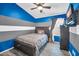 Cozy bedroom featuring stylish blue and grey striped walls, ceiling fan, and a comfortable bed at 4232 S 103Rd Ln, Tolleson, AZ 85353