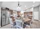 Eat-in kitchen with stainless steel appliances, wood cabinetry, and a bright chandelier at 4232 S 103Rd Ln, Tolleson, AZ 85353